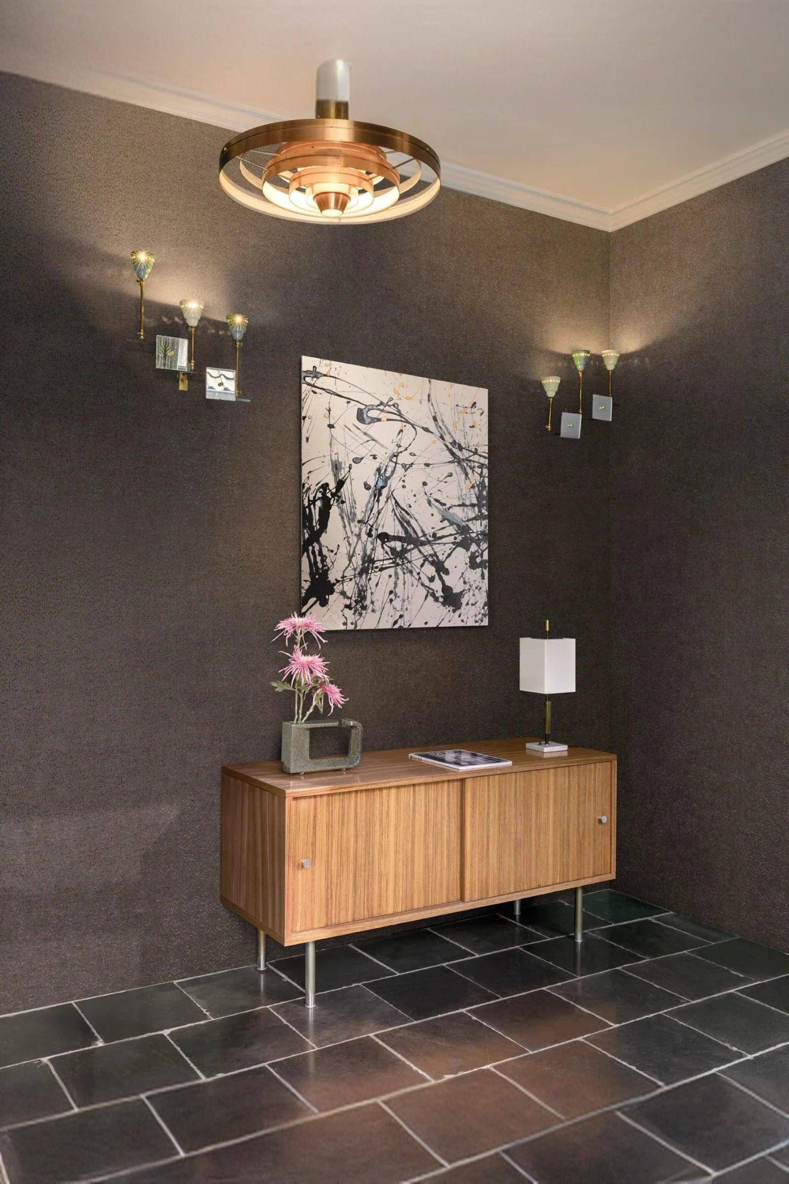 Modern luxury entryway with wooden sideboard, abstract wall art, minimalist lamp and flowers