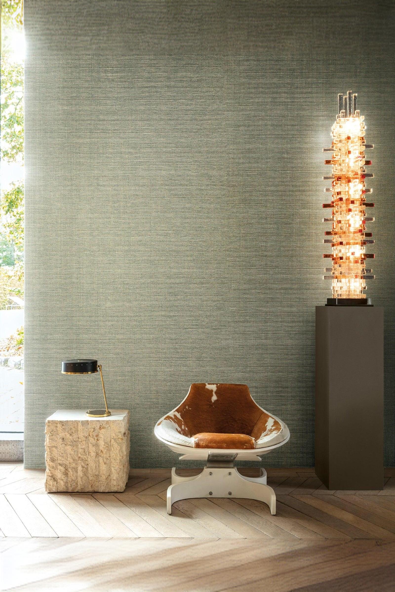 Modern luxury interior with brown cowhide lounge chair, stone side table, and tall designer lamp