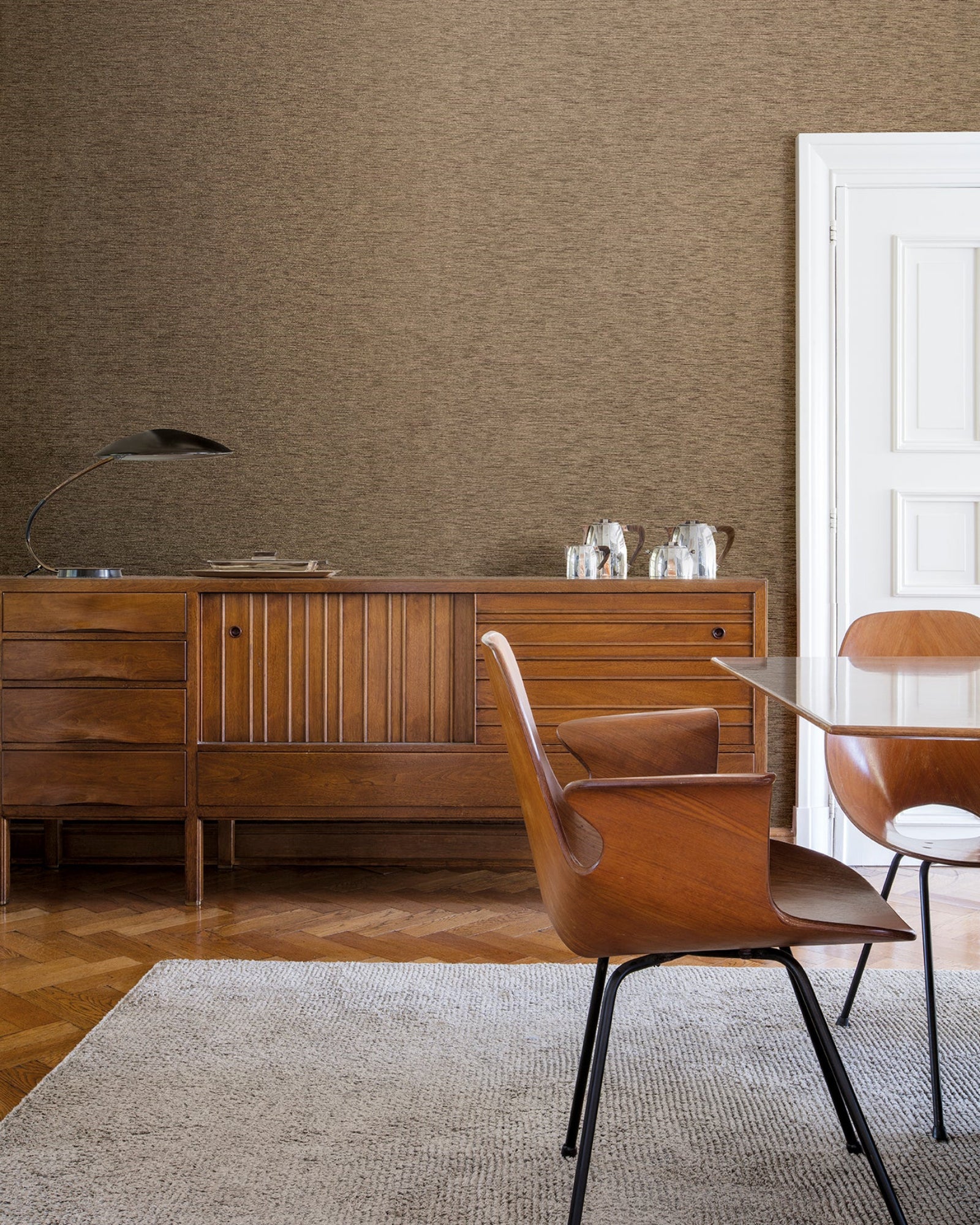 Mid-century modern luxury dining room with wooden furniture, textured brown wall, and minimalist décor