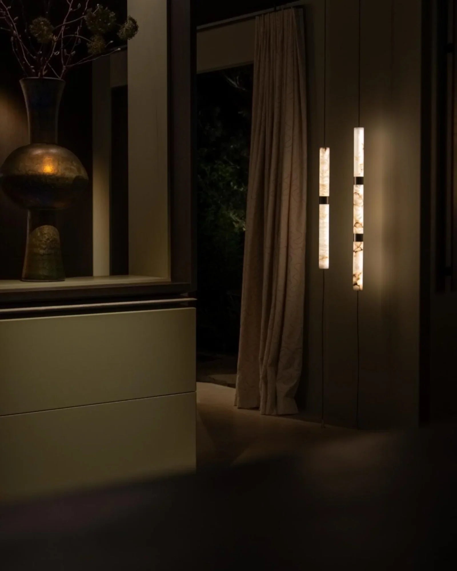 Modern luxury interior with elegant lighting, large vase and floor-to-ceiling curtain