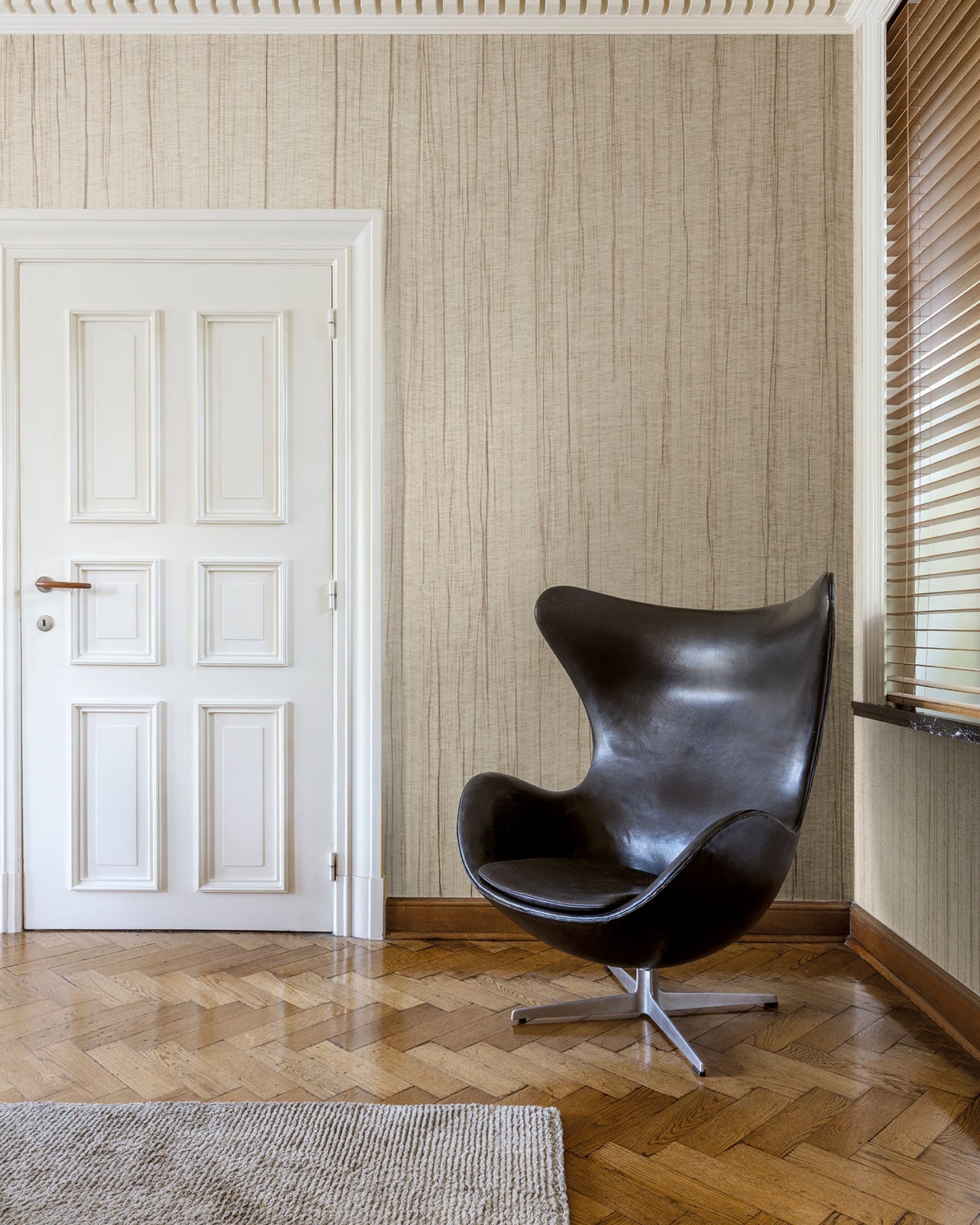 Modern black egg chair in elegant residential interior with herringbone wood floor