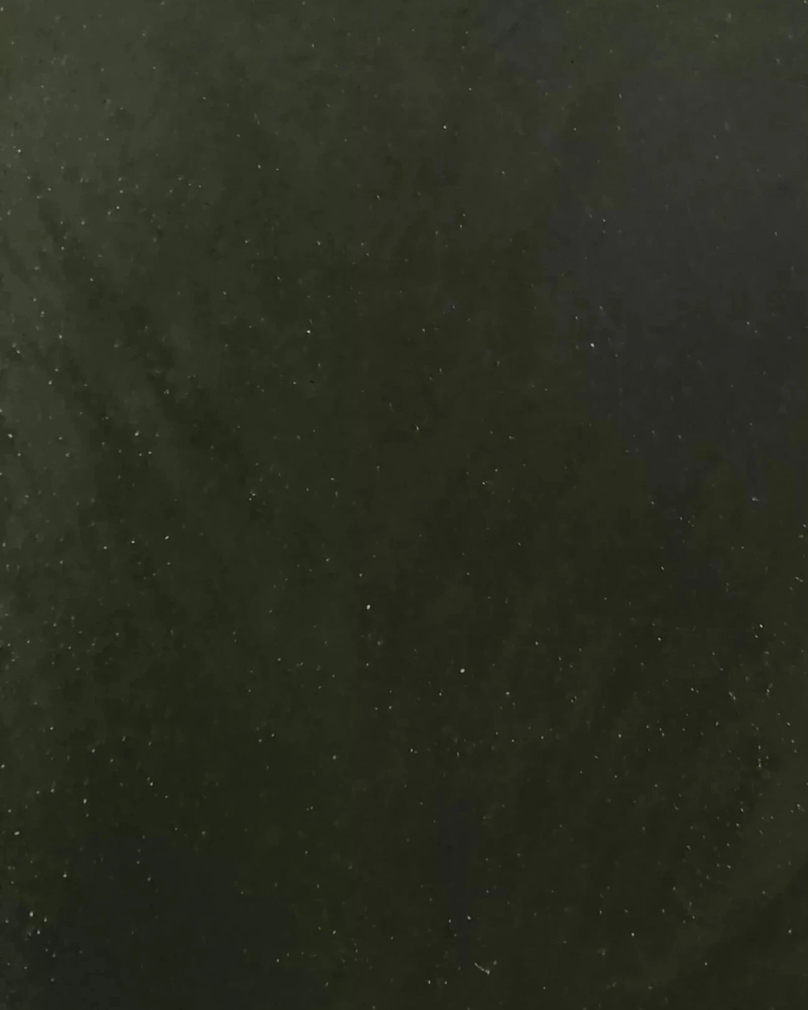 Close-up of dark green natural stone surface with subtle veining and speckled texture