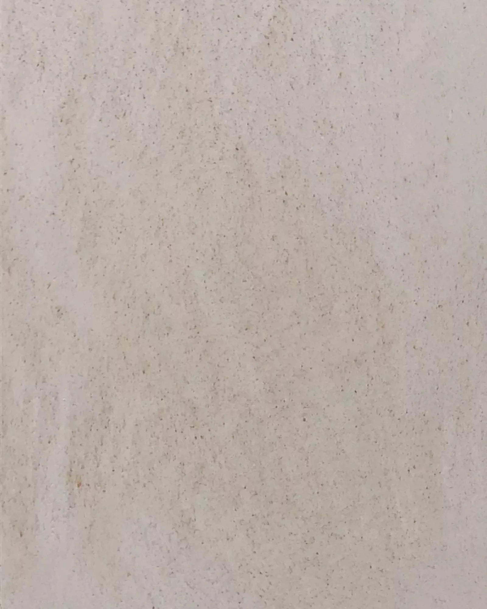 Close-up of a light beige stone texture with a subtle, natural speckled pattern