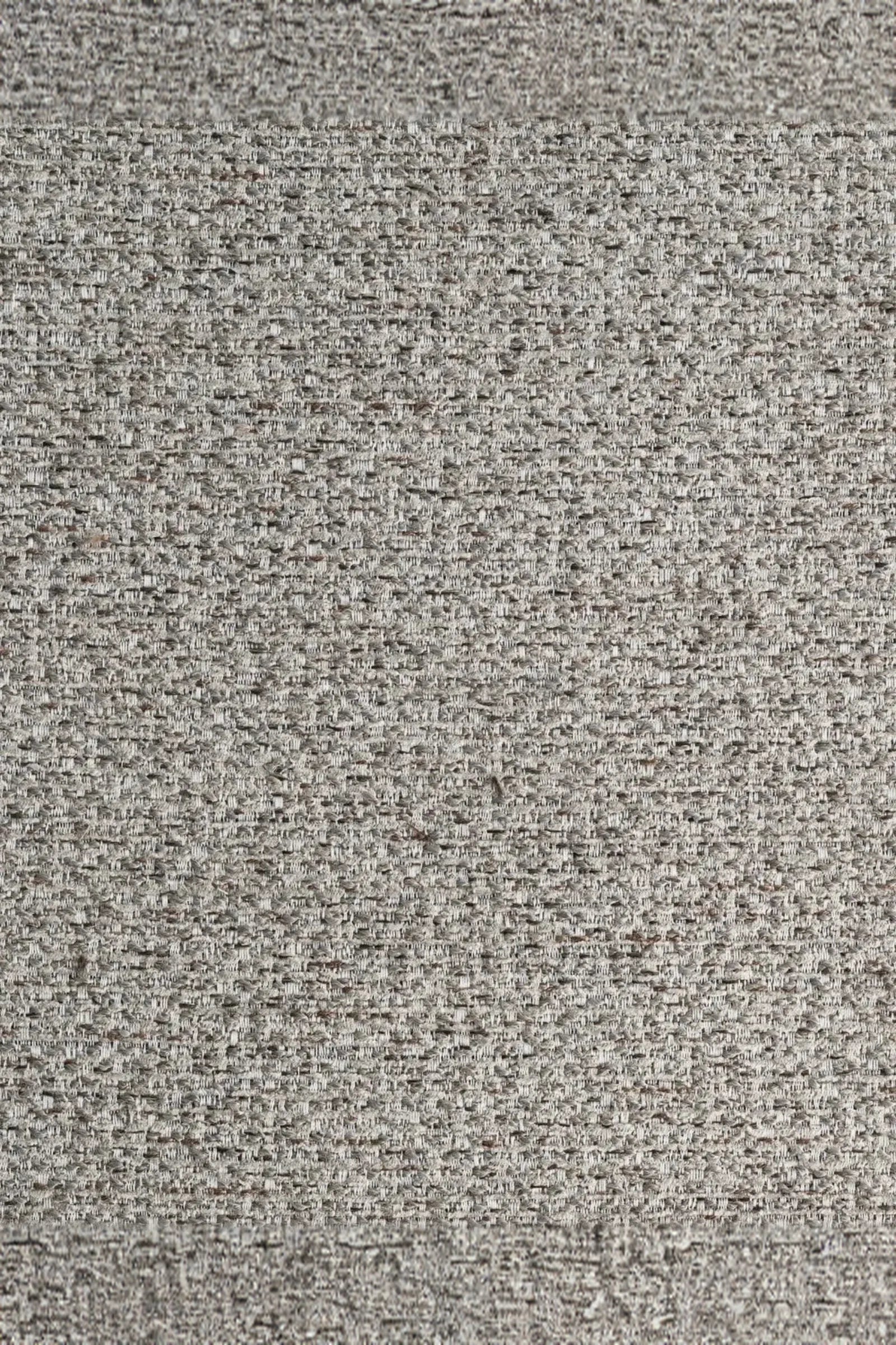 Close-up of light grey textured upholstery fabric with a woven pattern.
