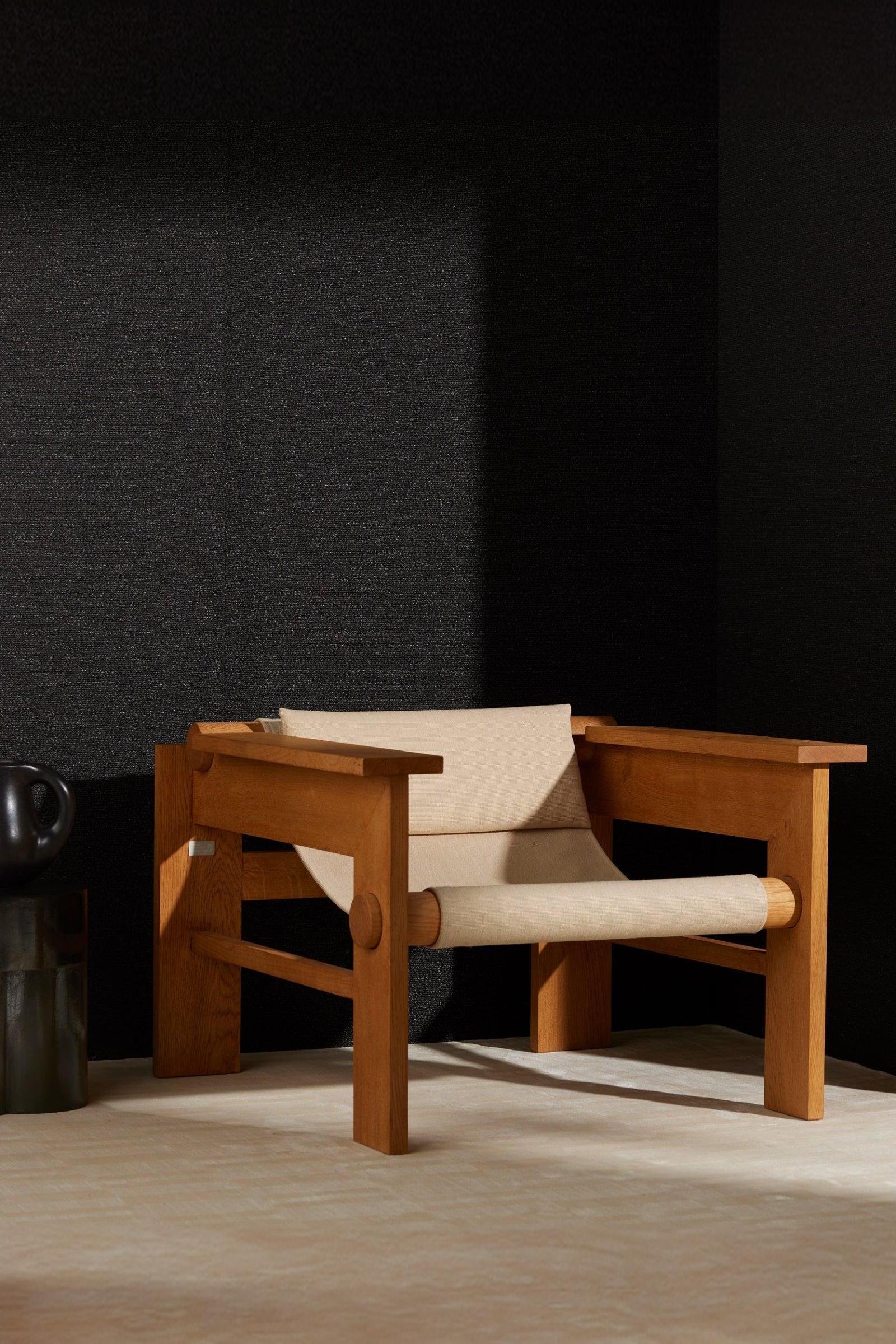Modern wooden lounge chair with beige fabric seat in a minimalist interior