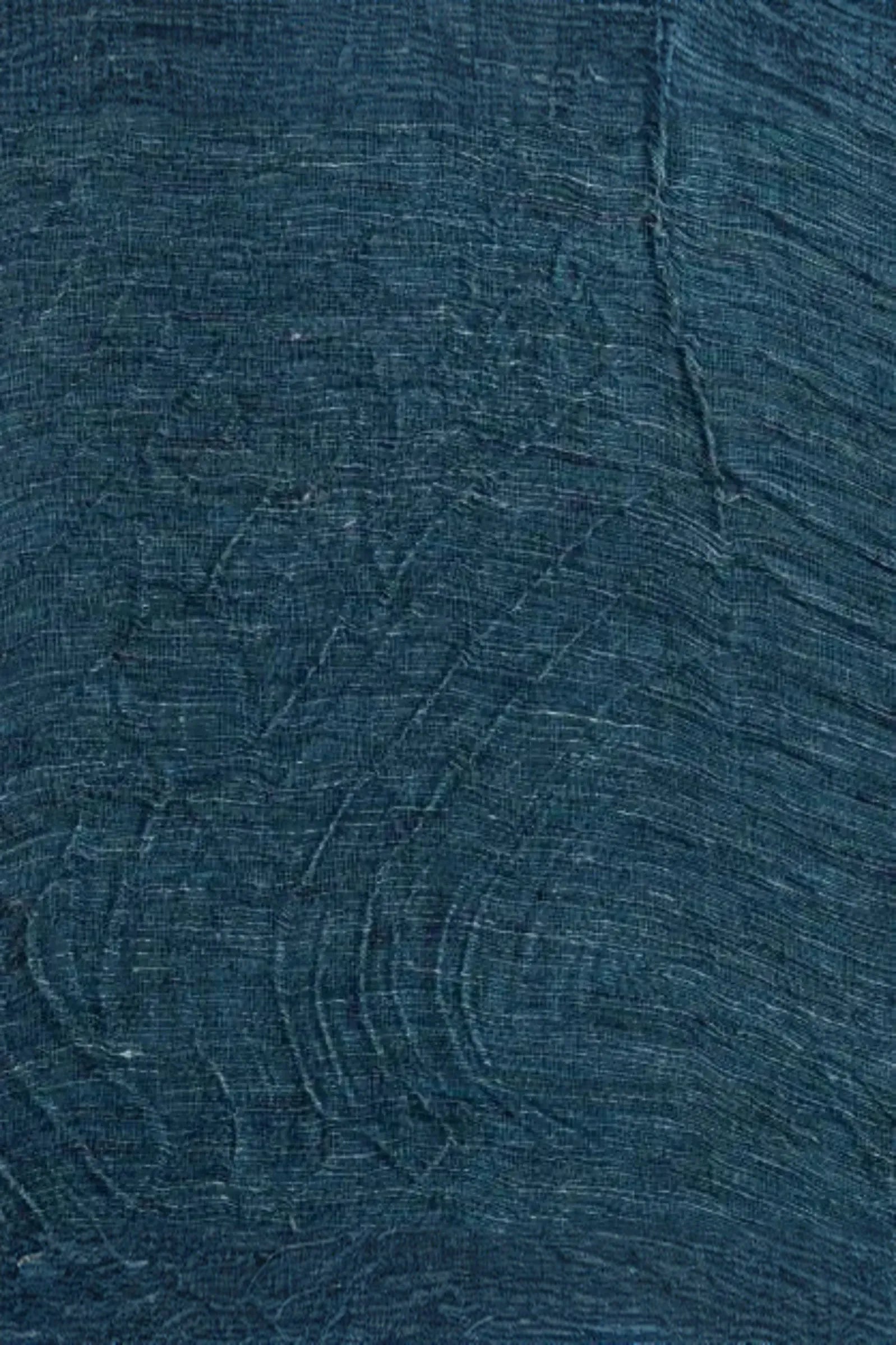 Textured blue surface with subtle sculptural patterns and fine fabric-like lines