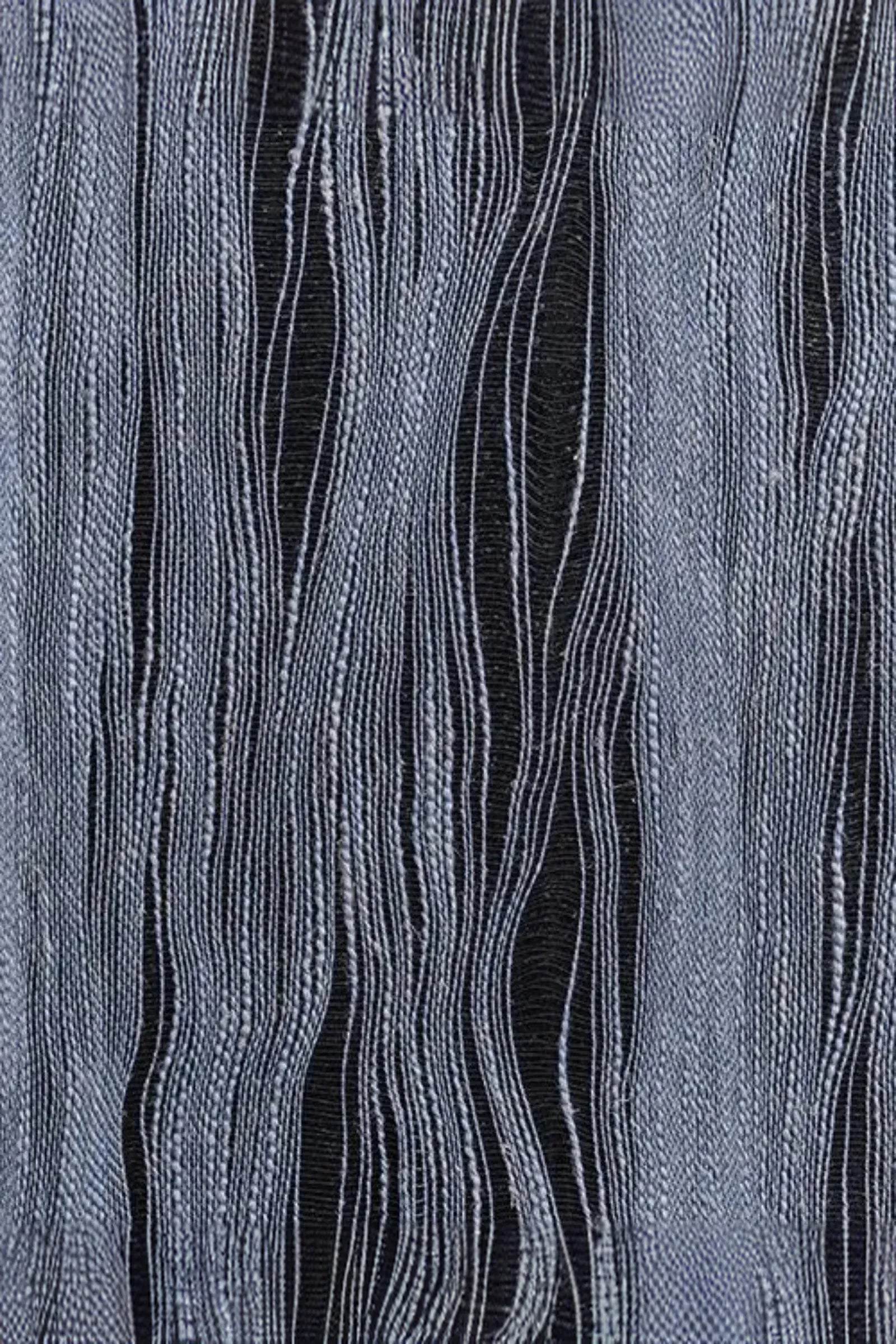 Close-up of textured woven fabric with flowing linear patterns in grey and black