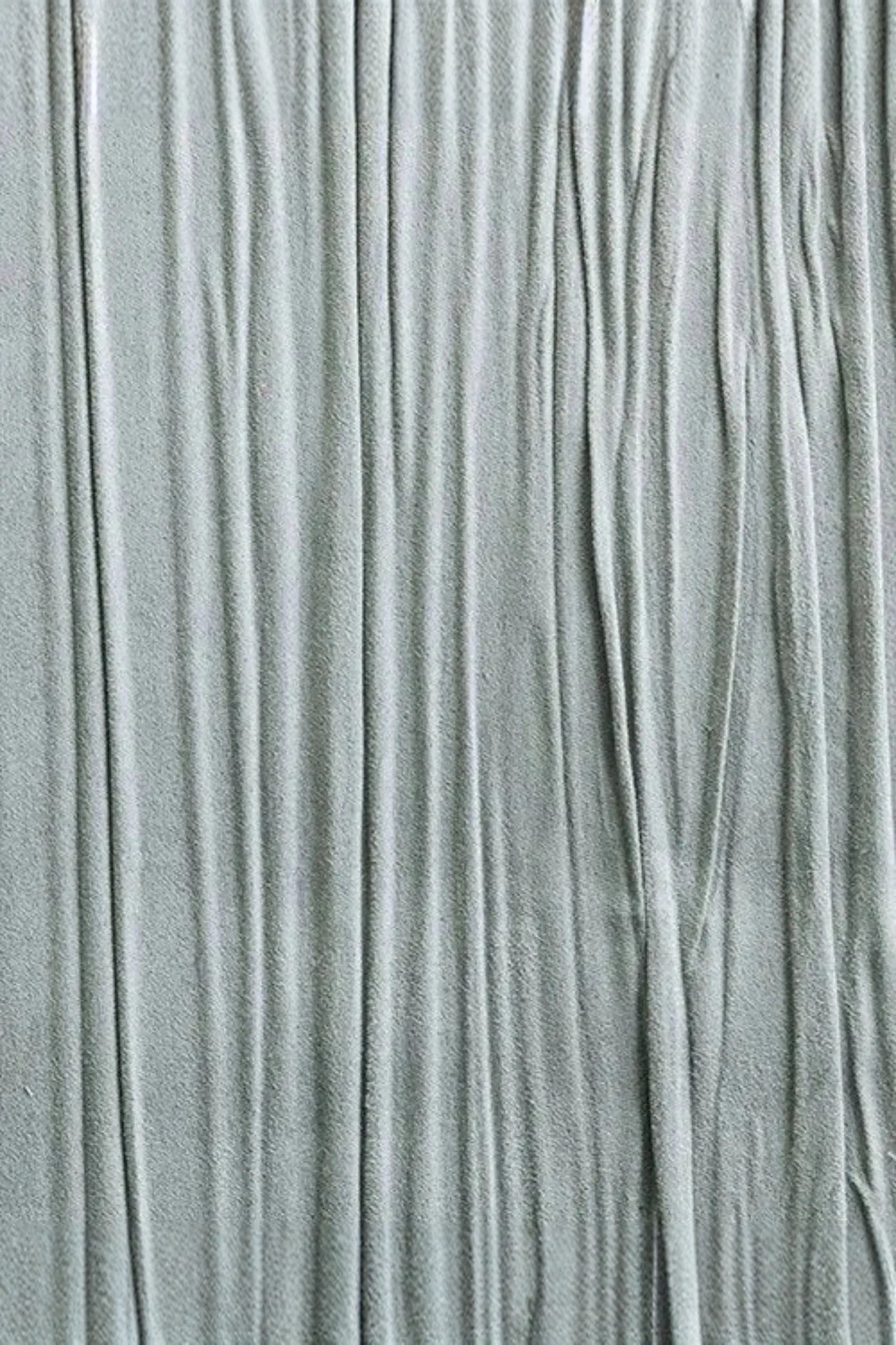 Close-up of light grey textured fabric with vertical pleats for luxury interior design