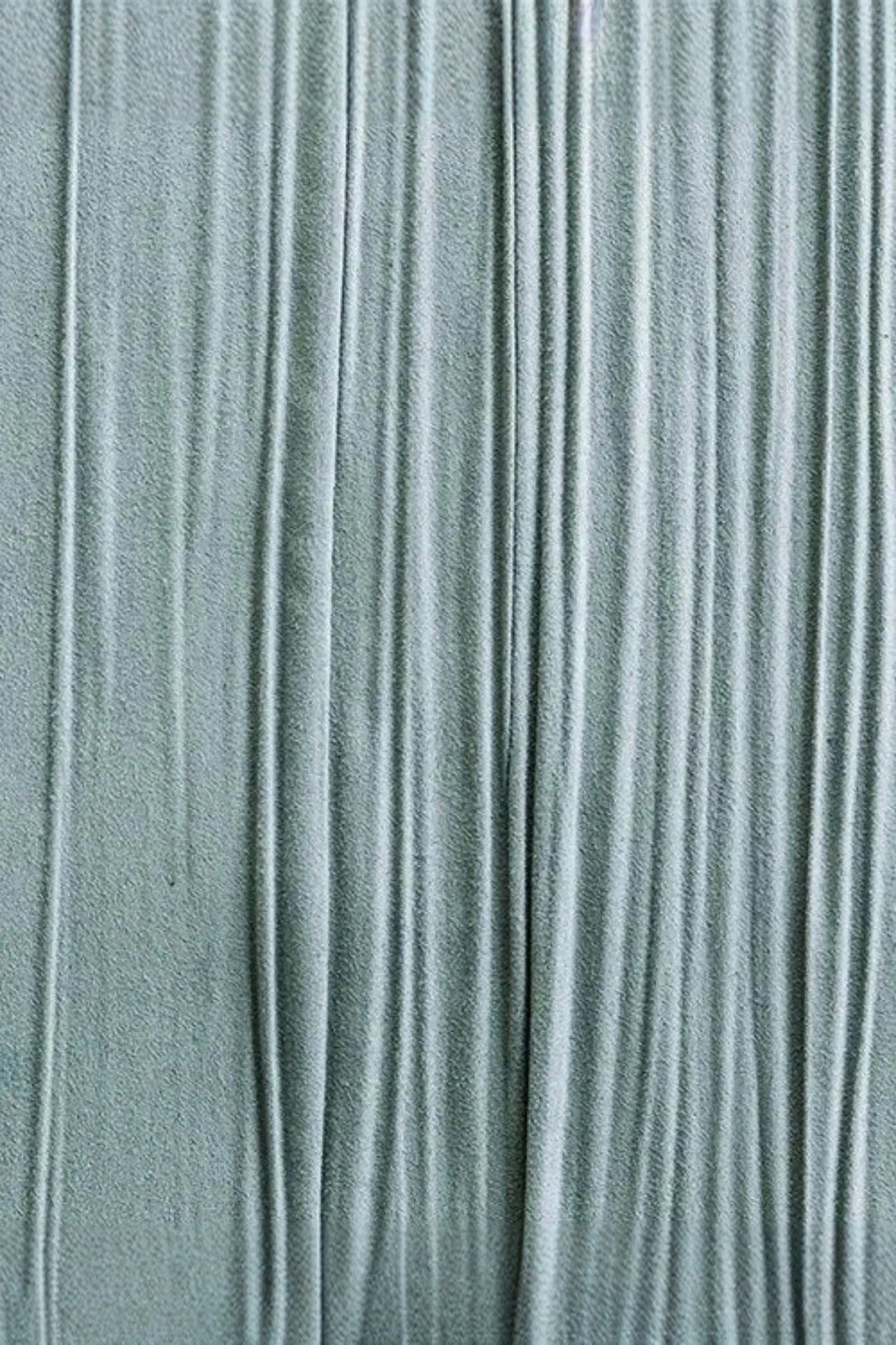 Textured light grey woven fabric with vertical pleats and soft draped surface