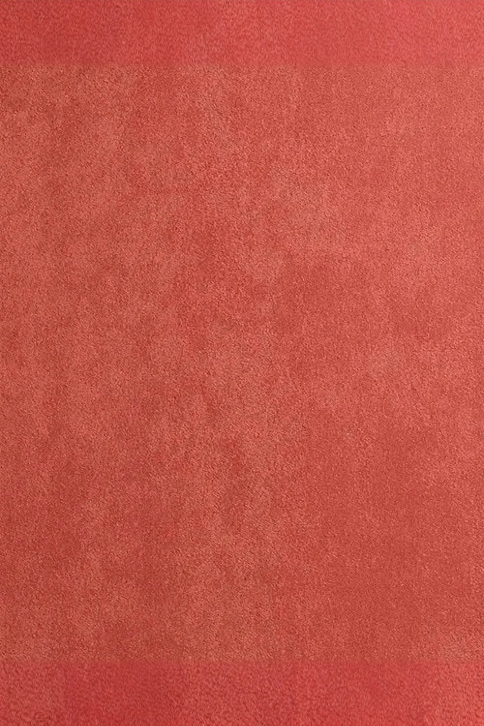 Coral pink suede fabric texture, soft and velvety surface, luxury interior material
