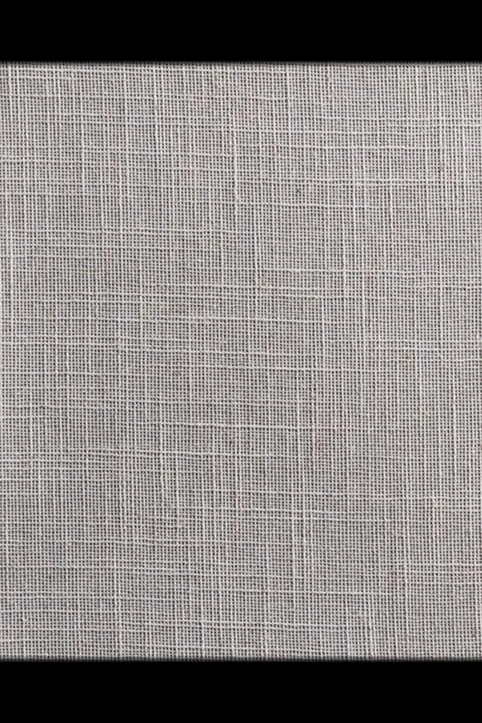 Close-up of textured beige woven fabric with intersecting linear patterns