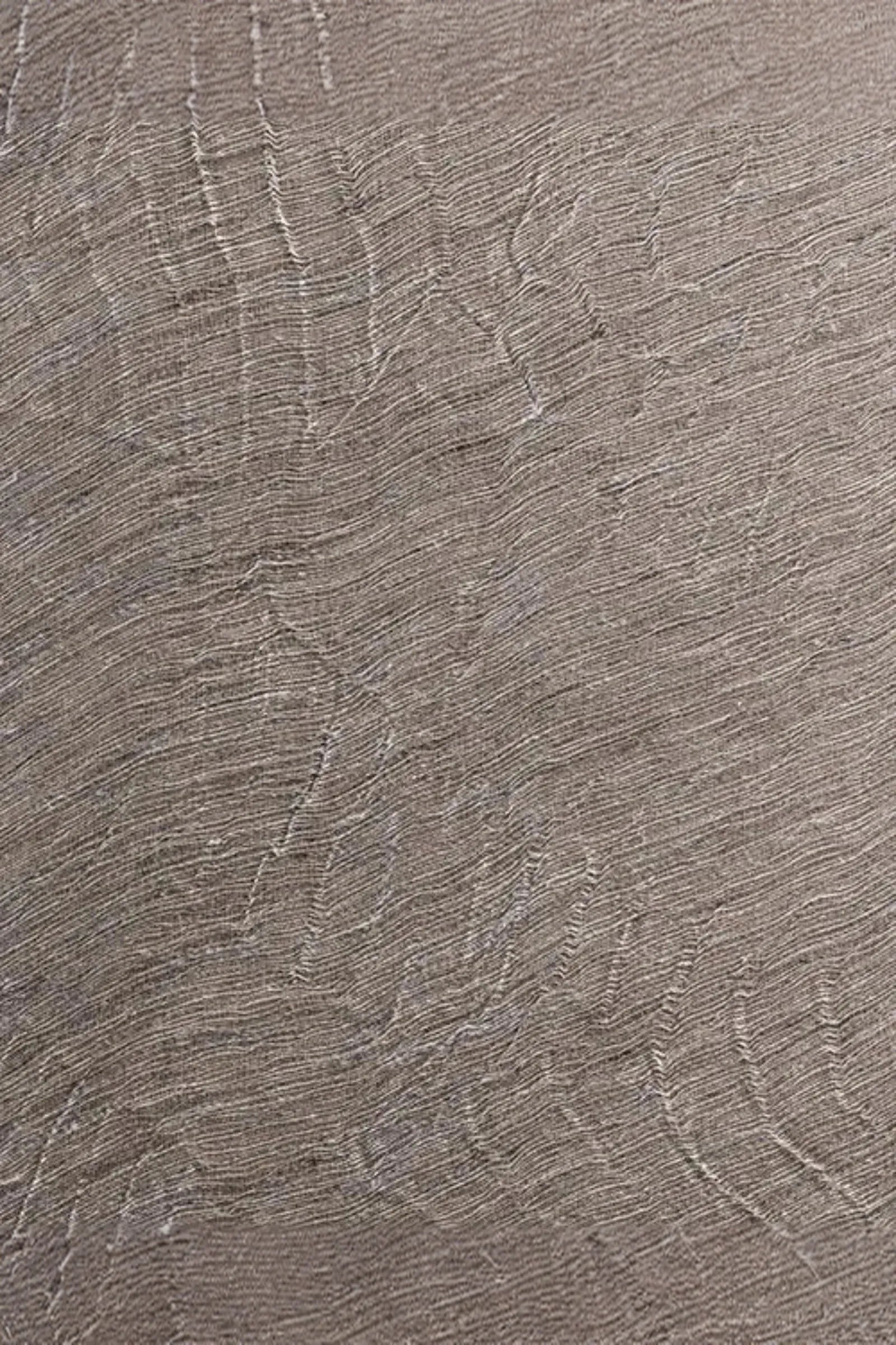 Close-up of textured woven fabric in neutral beige tones with organic line patterns
