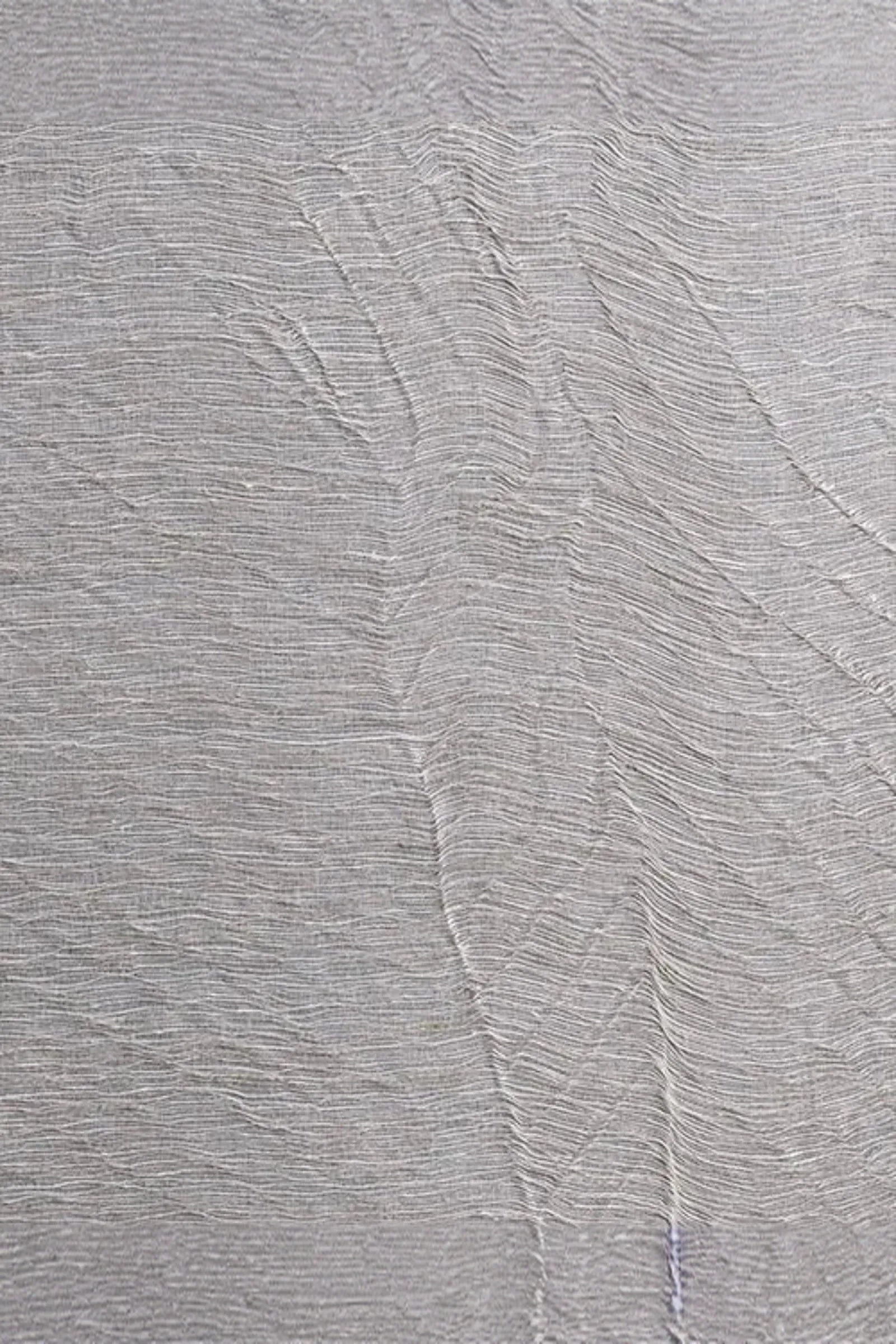Textured woven fabric in light grey with organic, wavy lines and natural linen pattern