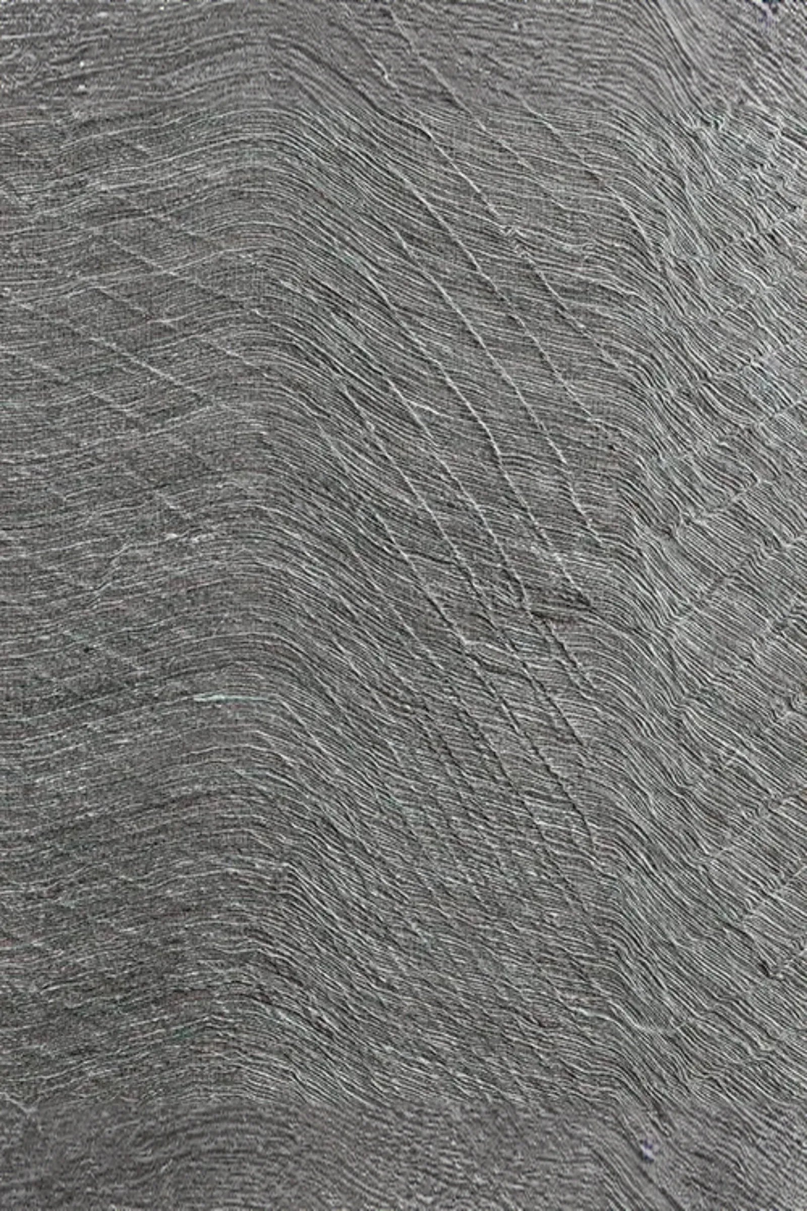 Close-up of textured gray woven textile with wavy, sculptural pattern