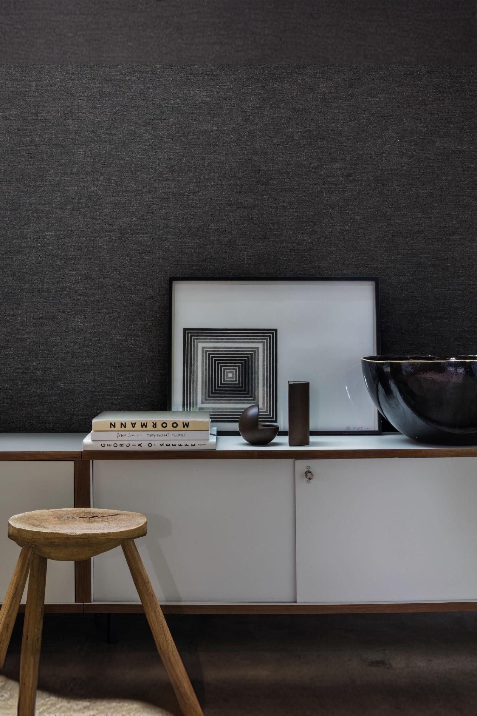 Modern luxury sideboard with minimal decor, geometric art, books, and a wooden stool