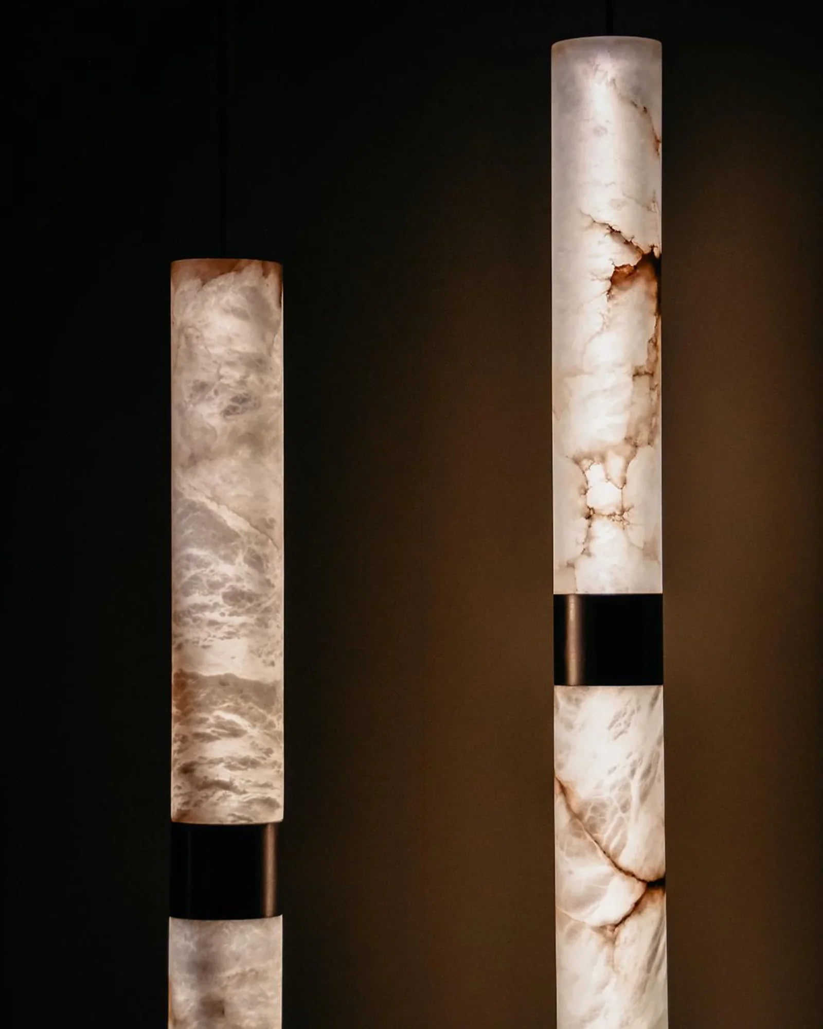 Close-up of modern cylindrical marble pendant lights in a luxury interior setting