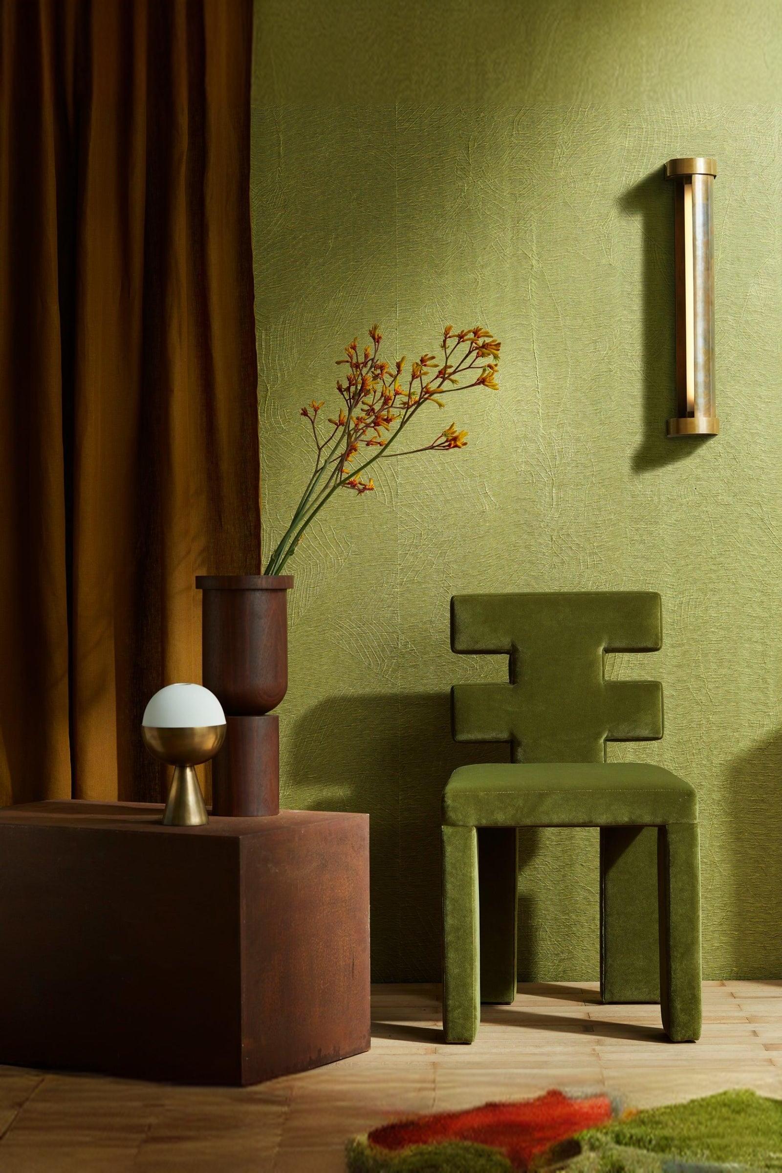Modern luxury interior with green geometric chair, textured olive wall, and minimalist decor