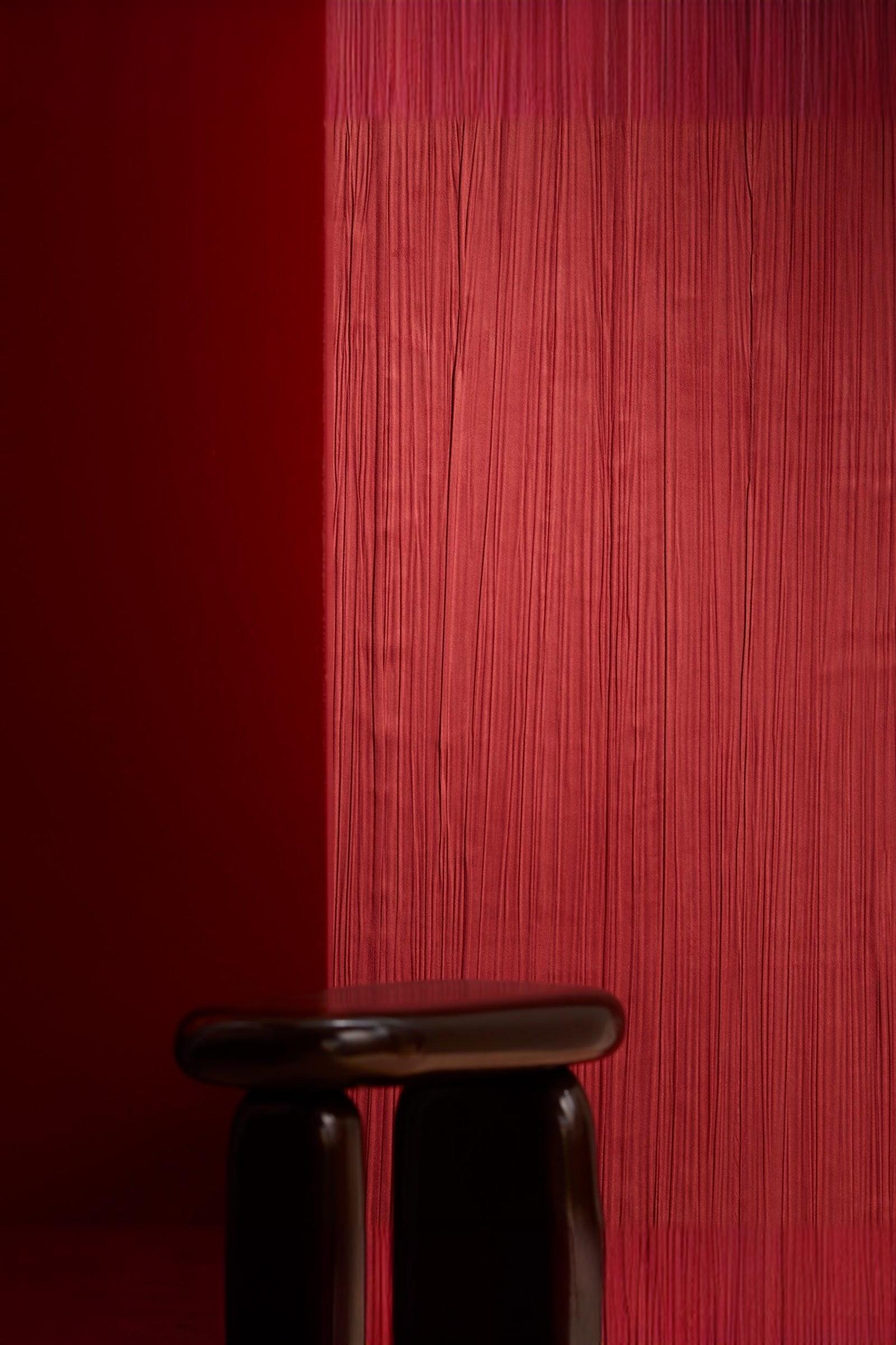 Modern brown stool against textured red wall in luxury residential interior
