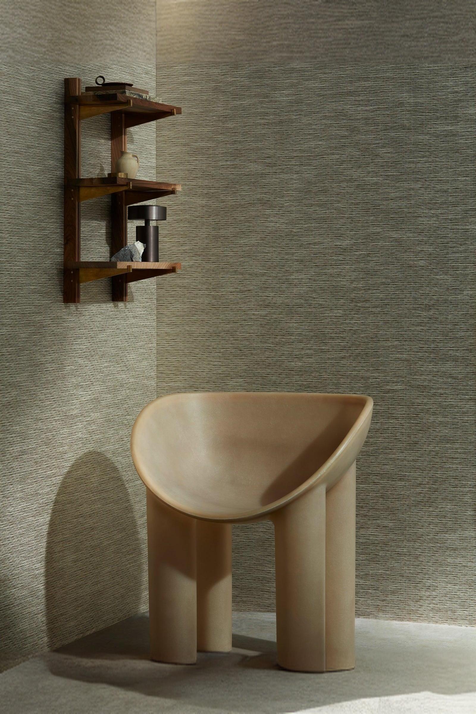 Modern minimalist chair with sculptural design and wooden wall shelf in a luxury interior