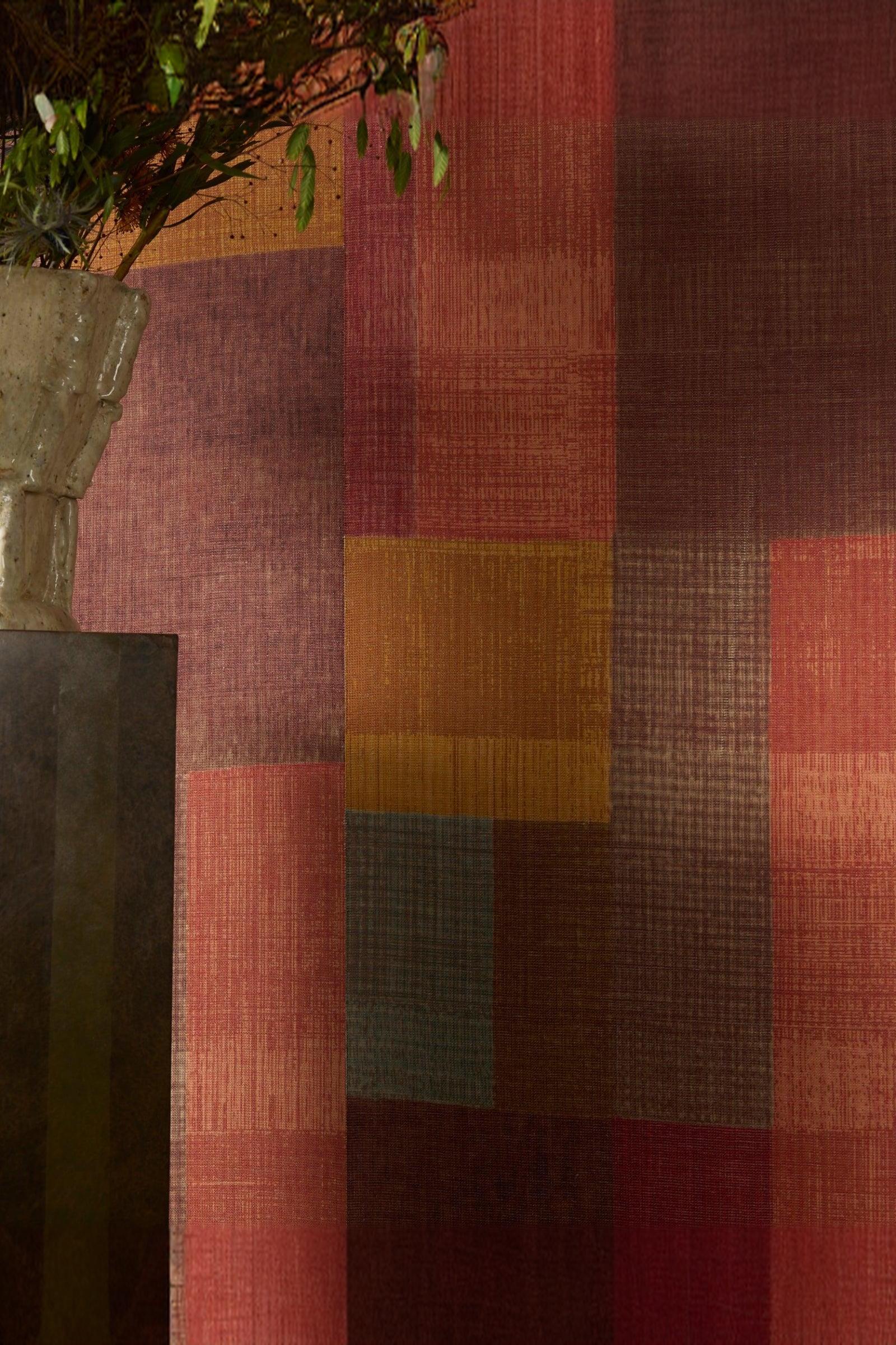 Colorful textured wall with patchwork pattern and a ceramic vase with greenery