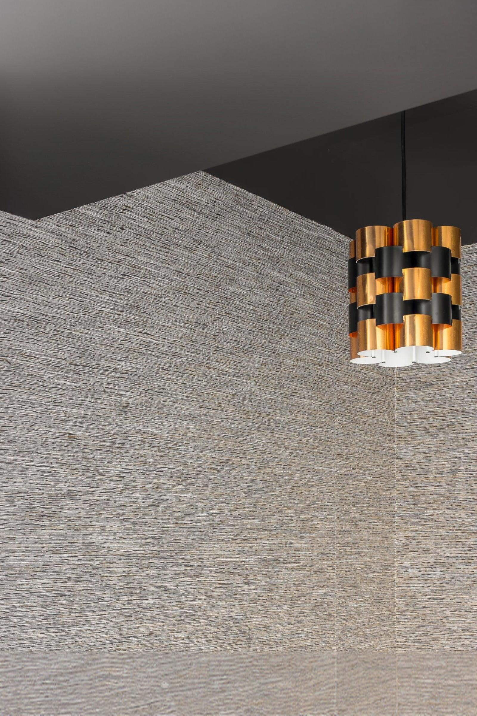 Modern gold and black pendant light in corner of luxury textured wall interior