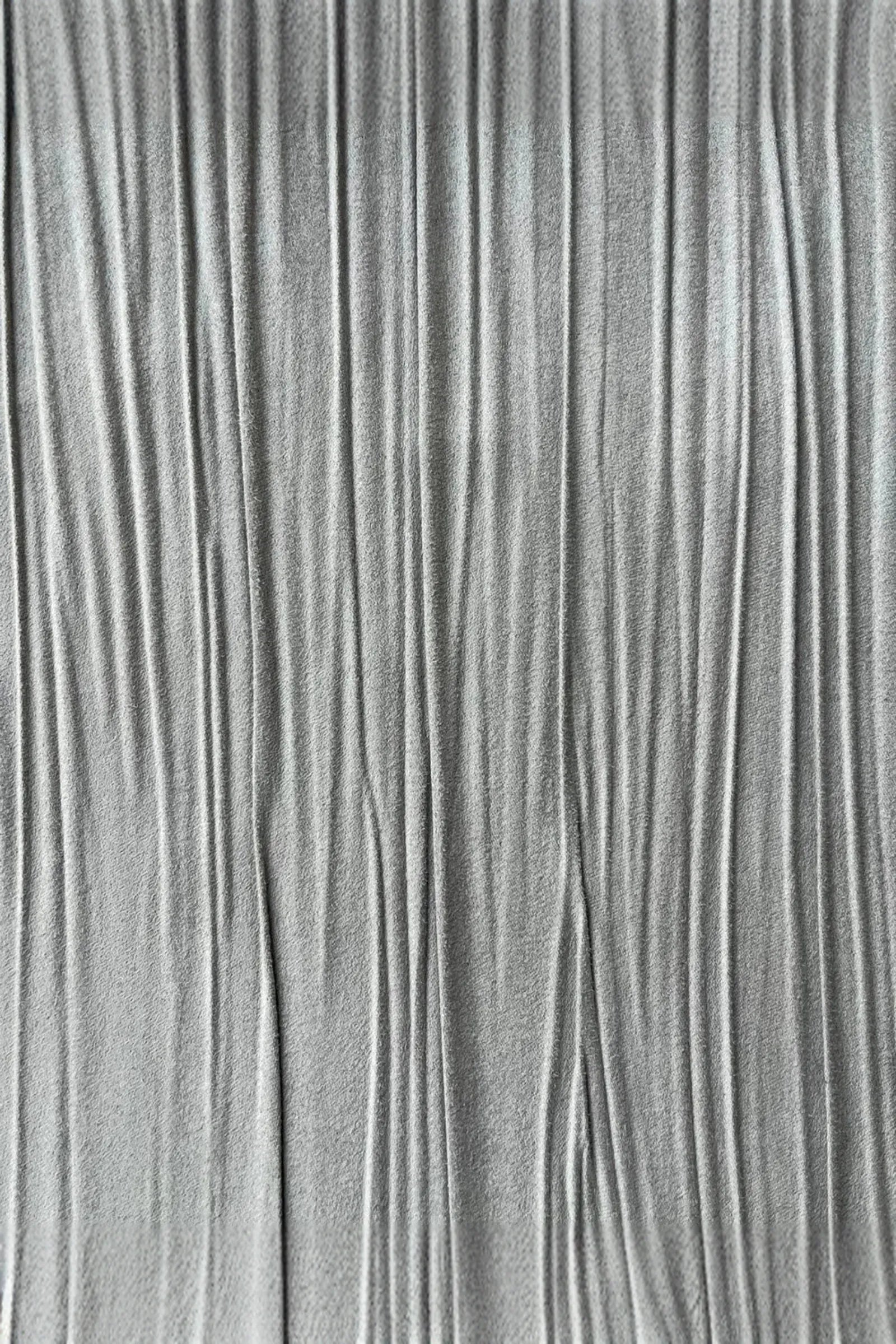 Close-up of textured grey fabric with vertical pleats, luxury interior material