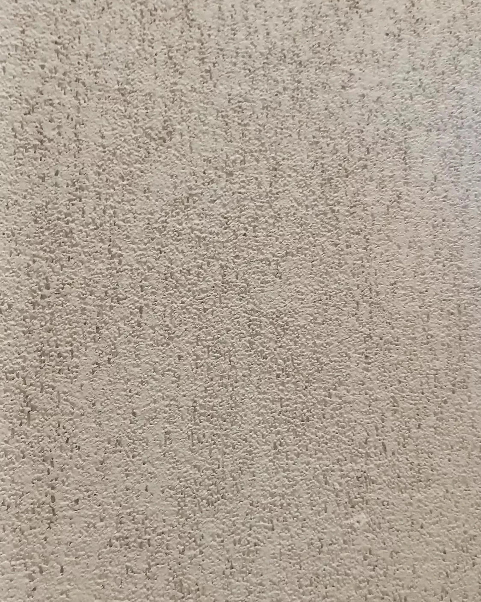 Beige textured wall surface with a subtle, sophisticated plaster finish for luxury interiors.